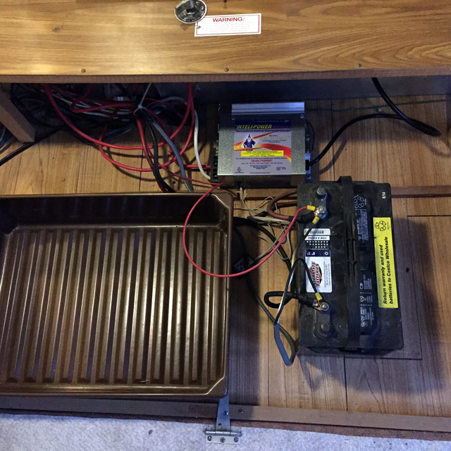 Testing out the new wiring with my old battery. The container will be under the couch - it's there for spacing. We are sacrificing the middle storage unit for the batteries.
